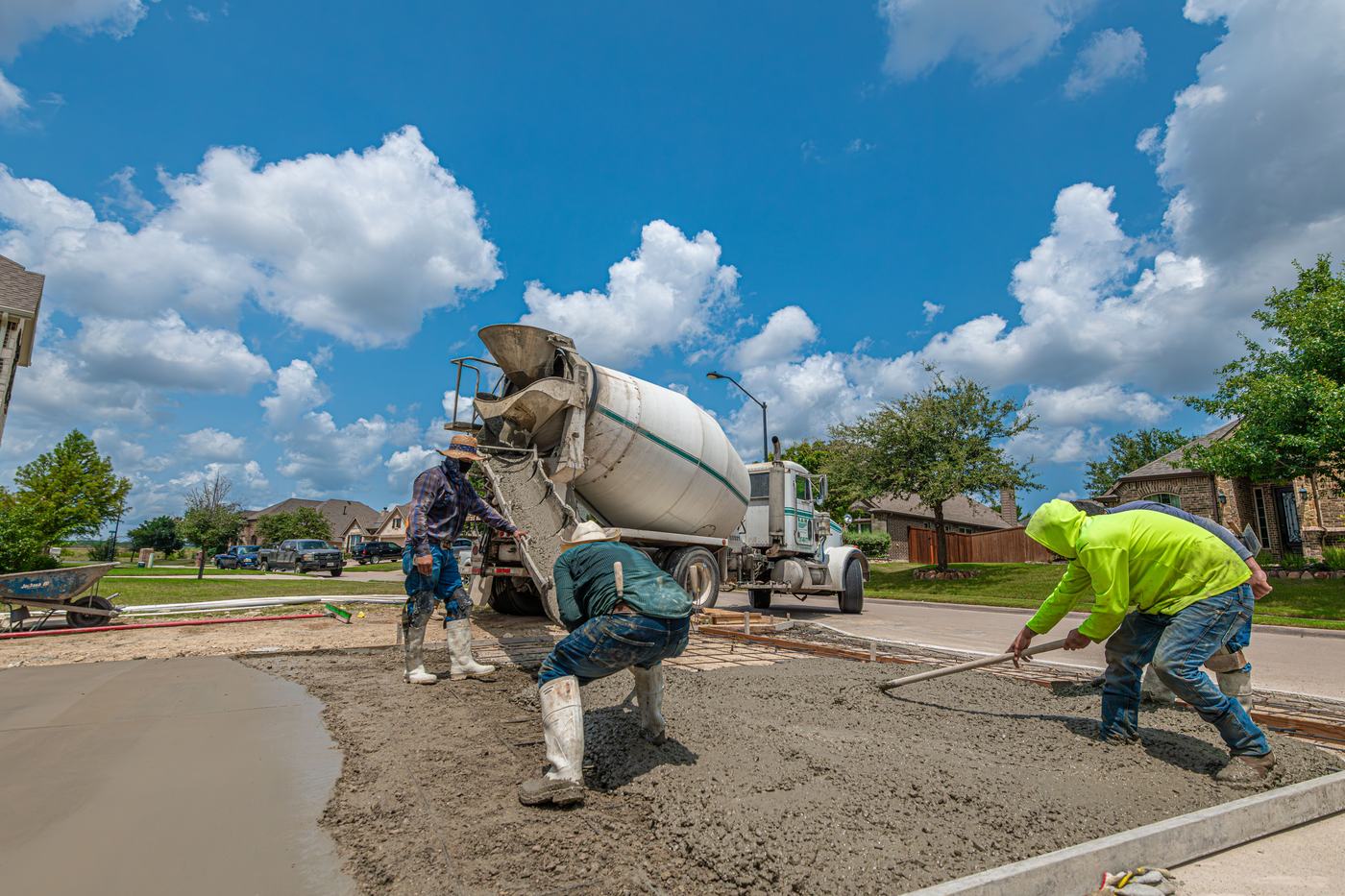 Crew screeding concrete from a mixer truck