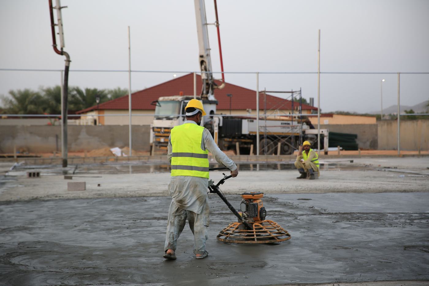Worker power-trowelling a large slab